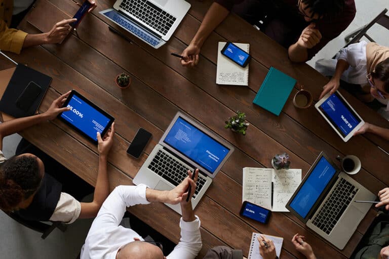 A table of employees work on their devices.